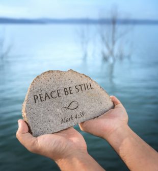 Peace Be Still stone held by the Sea of Galilee